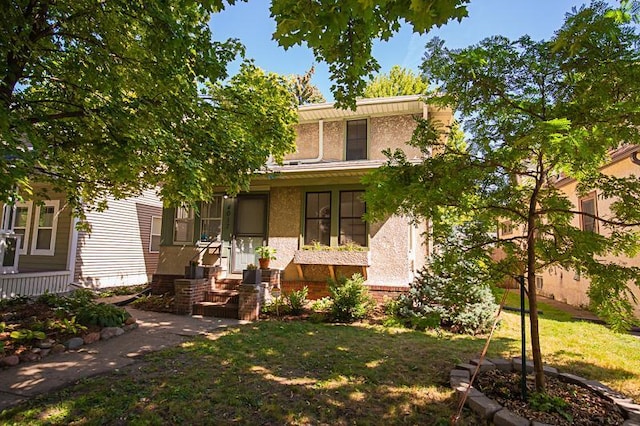 view of front of home with a front lawn and stucco siding