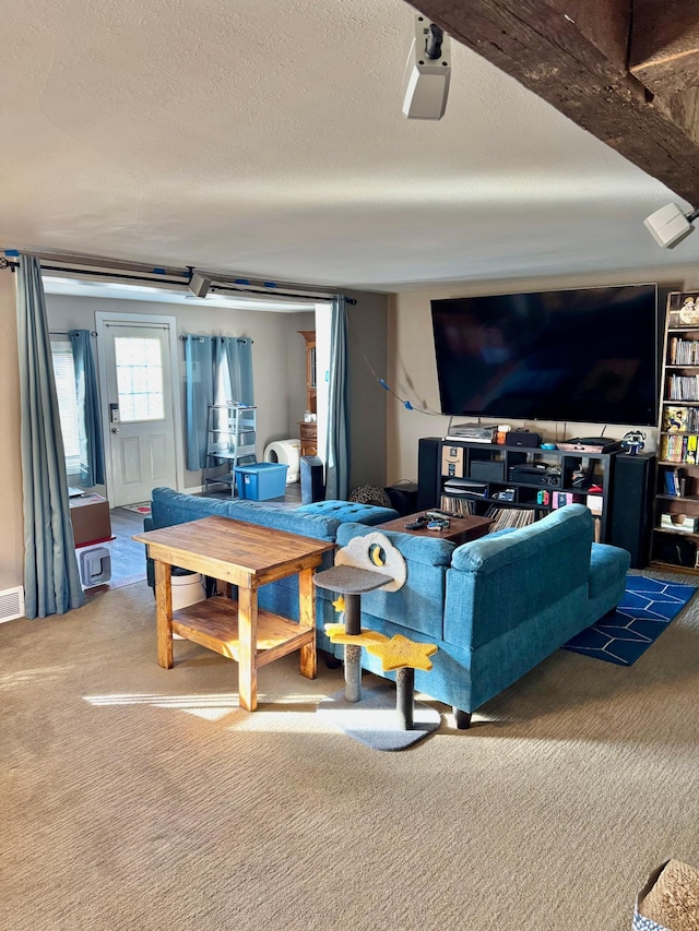 living room featuring carpet floors, visible vents, and a textured ceiling