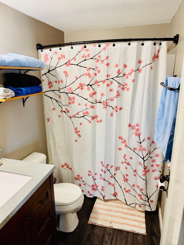 full bathroom featuring toilet, a shower with shower curtain, wood finished floors, and vanity