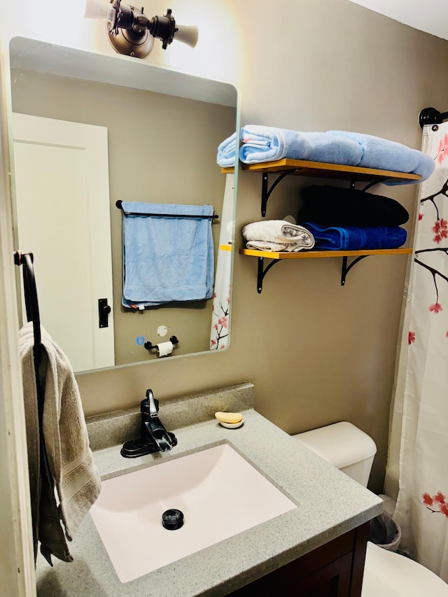 full bath featuring toilet, a shower with curtain, and vanity