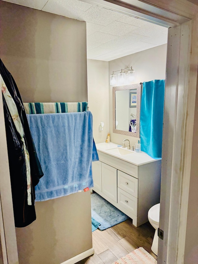 bathroom with toilet, wood finished floors, and vanity