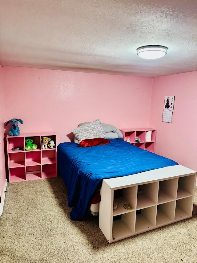 bedroom featuring a textured ceiling and carpet