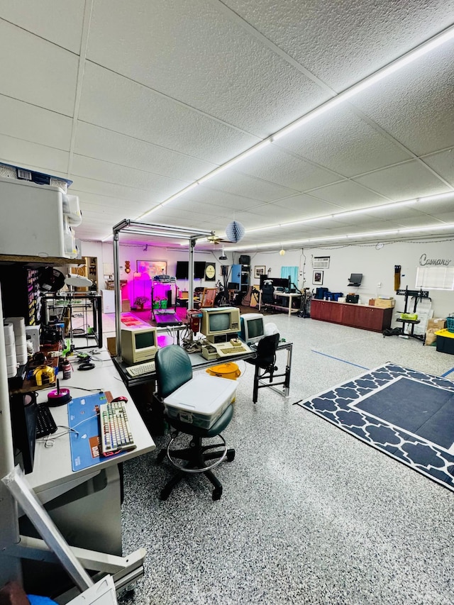 office space with a paneled ceiling and speckled floor