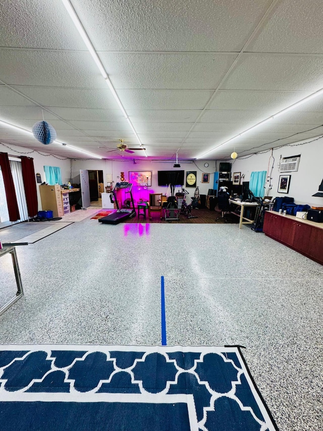 interior space featuring a drop ceiling and speckled floor