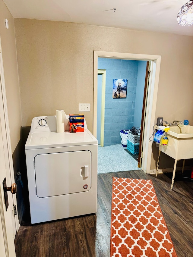 clothes washing area with laundry area, washer / clothes dryer, and dark wood-style flooring