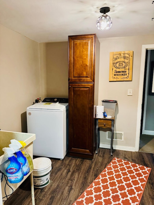 clothes washing area featuring laundry area, dark wood-type flooring, visible vents, baseboards, and washer / clothes dryer