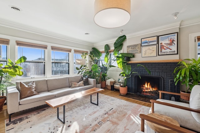 living room with a brick fireplace, wood finished floors, and crown molding