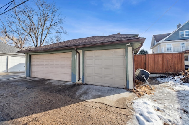 detached garage featuring fence