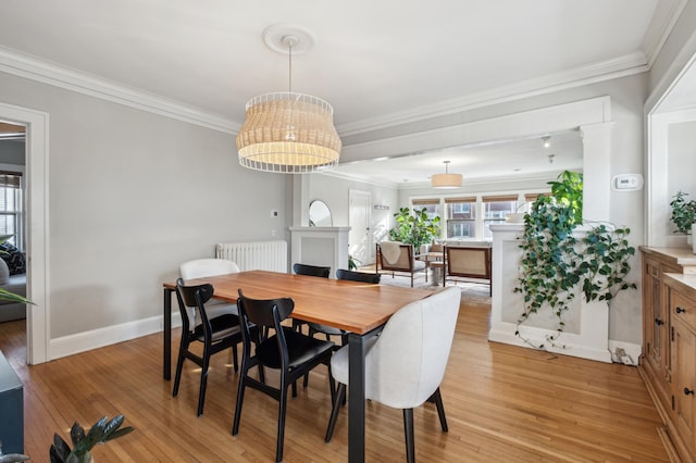 dining room with light wood-type flooring, ornamental molding, baseboards, and radiator heating unit