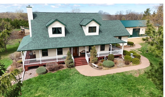 view of front of home with covered porch, roof with shingles, and a chimney