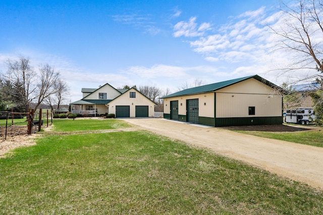 modern farmhouse with a front yard, a garage, fence, and driveway