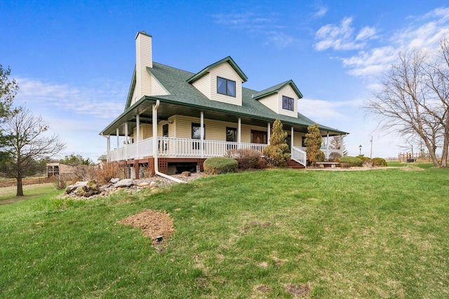 farmhouse inspired home with a chimney, a front yard, and covered porch