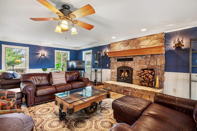 living area featuring plenty of natural light, crown molding, and a wainscoted wall