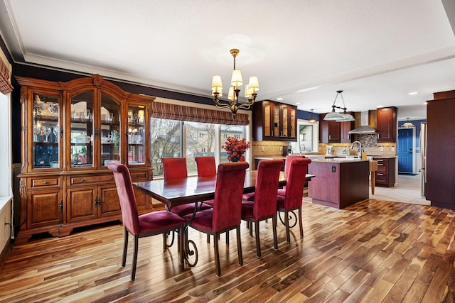 dining room featuring a chandelier, recessed lighting, and wood finished floors