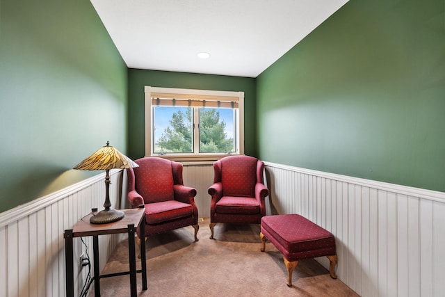 living area featuring carpet flooring and a wainscoted wall