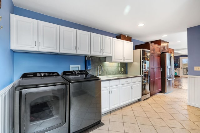 laundry room featuring a sink, cabinet space, independent washer and dryer, light tile patterned flooring, and recessed lighting