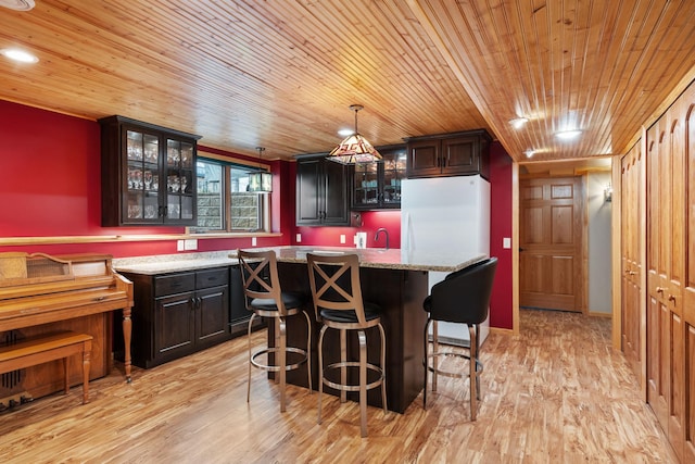 bar with wooden ceiling, light wood finished floors, decorative light fixtures, and a sink