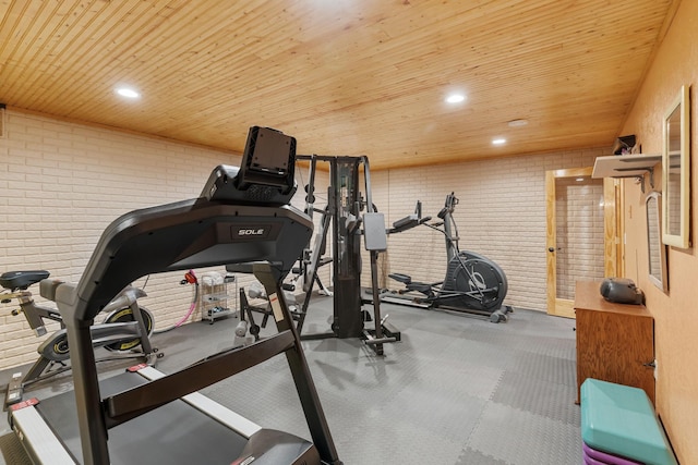 exercise area featuring brick wall, recessed lighting, and wood ceiling