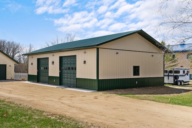 exterior space with an outbuilding, metal roof, fence, and a garage