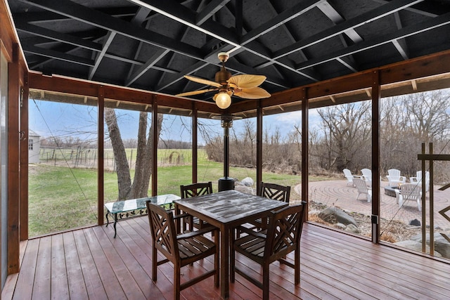 sunroom featuring ceiling fan, outdoor dining area, and plenty of natural light