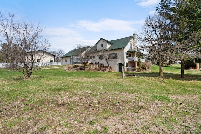 exterior space with fence, a chimney, and a lawn