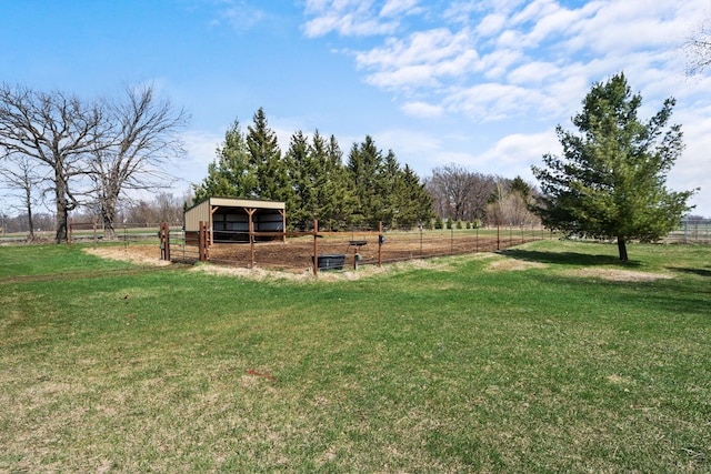 view of yard featuring fence, a rural view, an outbuilding, and an outdoor structure