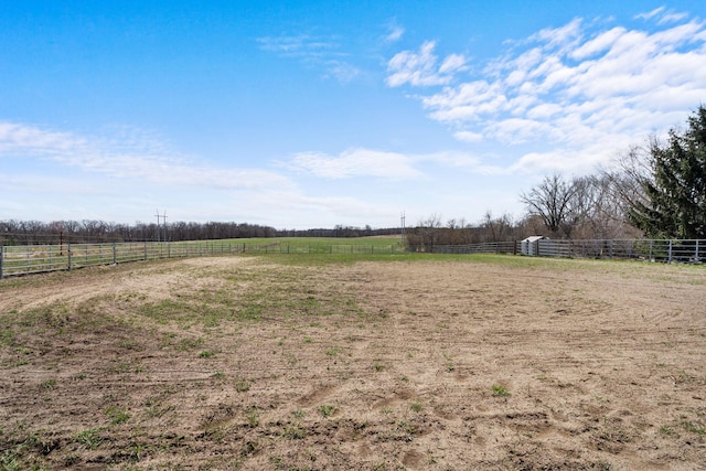 view of yard featuring a rural view, an enclosed area, and fence