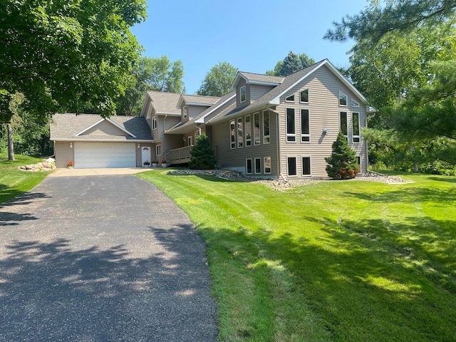 view of front of property with roof with shingles, driveway, a garage, and a front yard