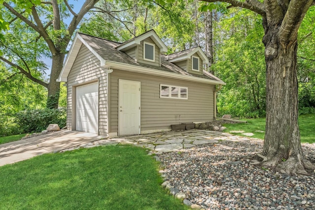 view of outbuilding featuring concrete driveway, an outdoor structure, and a garage