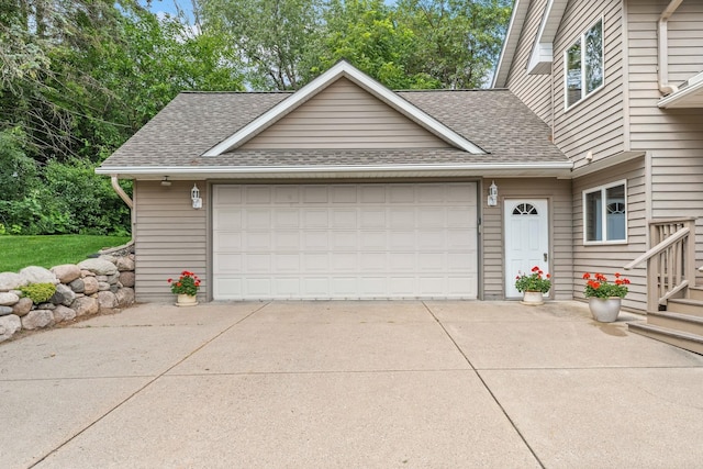 view of front of property with concrete driveway and a shingled roof