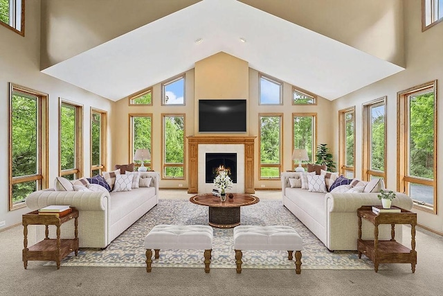 carpeted living area featuring baseboards, high vaulted ceiling, recessed lighting, and a lit fireplace