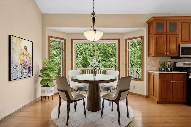 dining room featuring plenty of natural light, light wood-style flooring, and baseboards