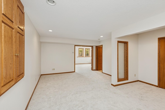 unfurnished room with light carpet, baseboards, and recessed lighting