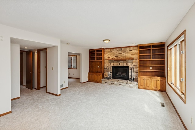 unfurnished living room with light carpet, baseboards, visible vents, and a fireplace