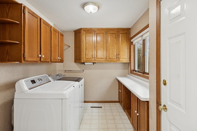 laundry room featuring cabinet space, washing machine and clothes dryer, baseboards, and light floors