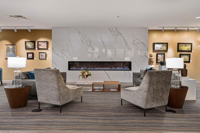 sitting room featuring visible vents, a fireplace, carpet flooring, and rail lighting