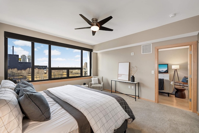 carpeted bedroom with a ceiling fan, visible vents, and baseboards