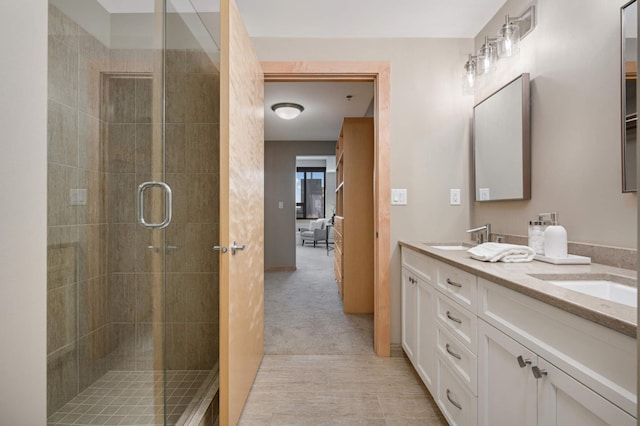 full bath with double vanity, a stall shower, and a sink