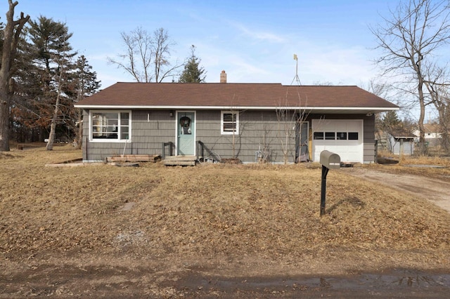 ranch-style house featuring driveway, a chimney, and an attached garage