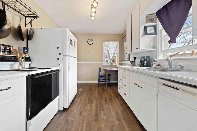 kitchen featuring white appliances, light countertops, dark wood-type flooring, and a sink