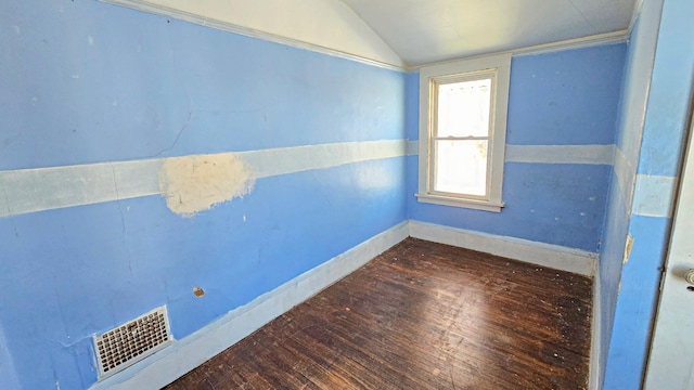 unfurnished room with visible vents, baseboards, lofted ceiling, and hardwood / wood-style floors