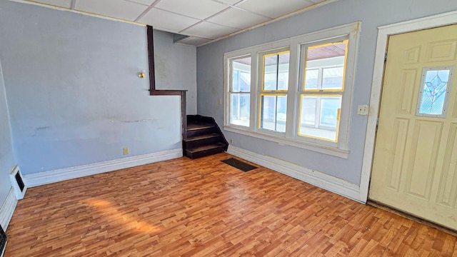 foyer with baseboards, visible vents, and wood finished floors