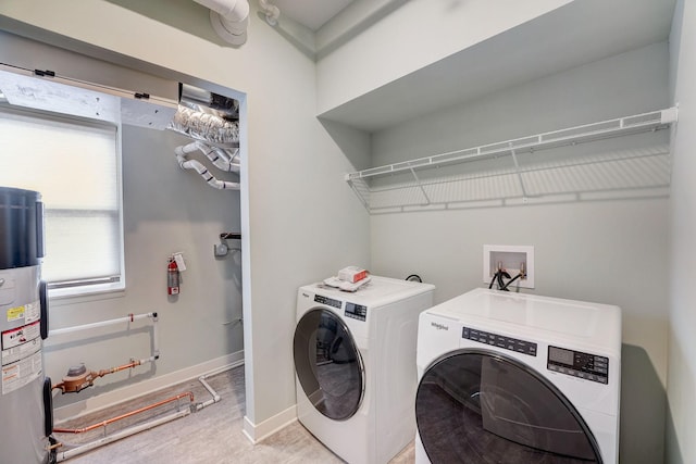 laundry area featuring baseboards, water heater, laundry area, light wood-style flooring, and independent washer and dryer