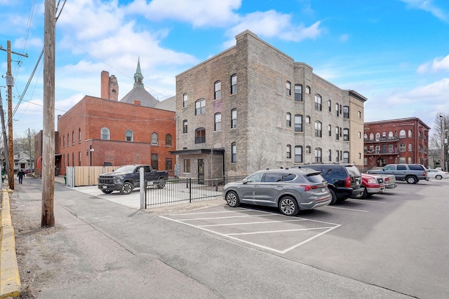 view of property with uncovered parking and fence