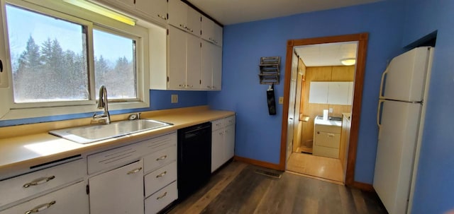 kitchen featuring freestanding refrigerator, black dishwasher, white cabinets, and a sink