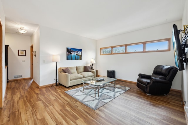 living area featuring light wood-type flooring, visible vents, and baseboards