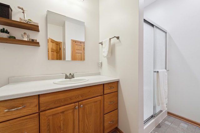 bathroom with tile patterned floors, a shower stall, vanity, and baseboards