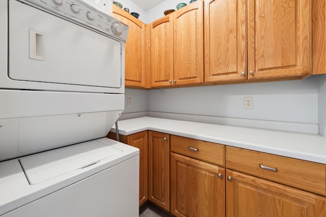 washroom featuring cabinet space and stacked washer and clothes dryer