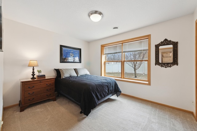 bedroom with light colored carpet, visible vents, and baseboards