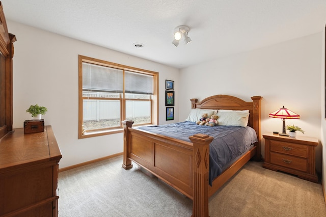 bedroom with light carpet, visible vents, and baseboards